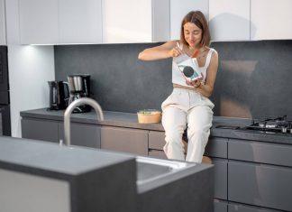 A modern konyha központi elemei: milyen nagygépeket válassz? konyhapulton ülő nő